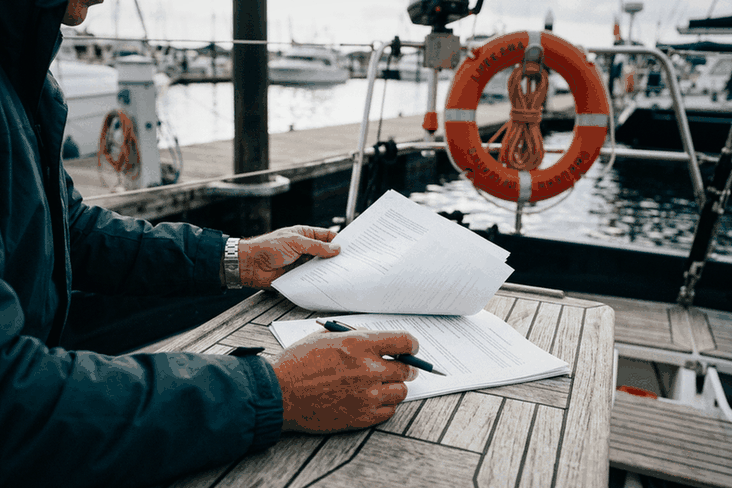 Boat owner reading a boat insurance quote on deck