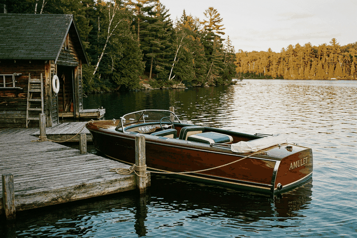 Restored classic wooden runabout tied at a boathouse dock