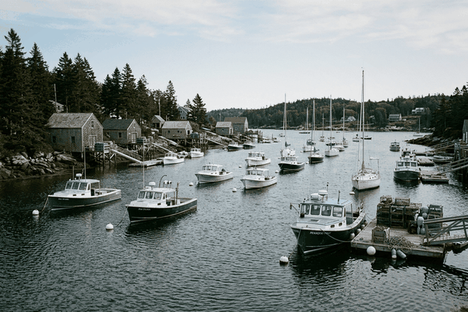 Lobster boats and sailboats on moorings in a rocky New England harbor, as kept by many Massachusetts boat owners