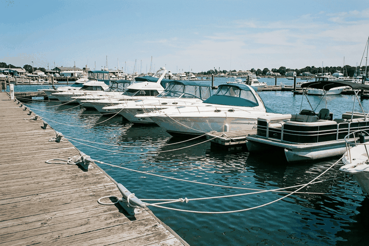 Boats in their slips along a marina finger pier, the boats Boat Insurance Compare prices